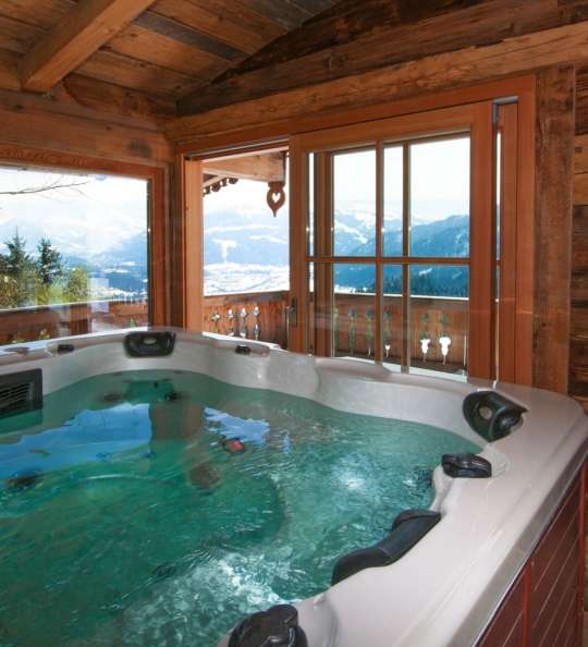 Whirlpool in einem Chalet mit Blick auf schneebedeckte Berge